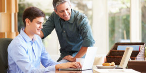 Student and father looking at a laptop. together
